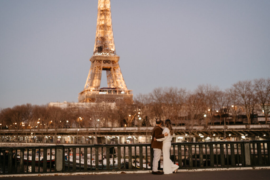 Paris Elopement Packages Elopement Photographer Videographer winter elopement couple hugging Eiffel Tower view Bir Hakeim