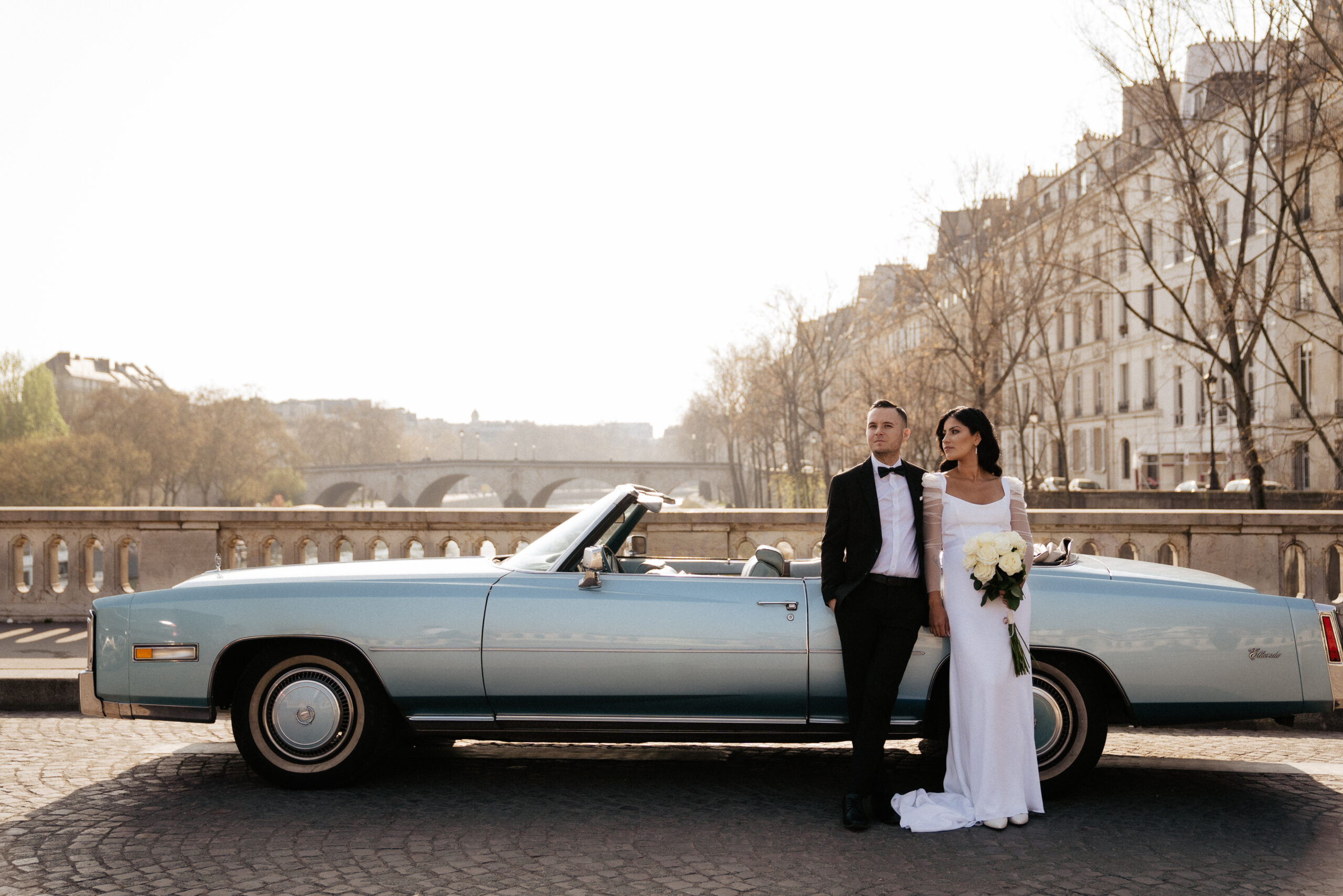 cool couple posing with vintage car by the seine
